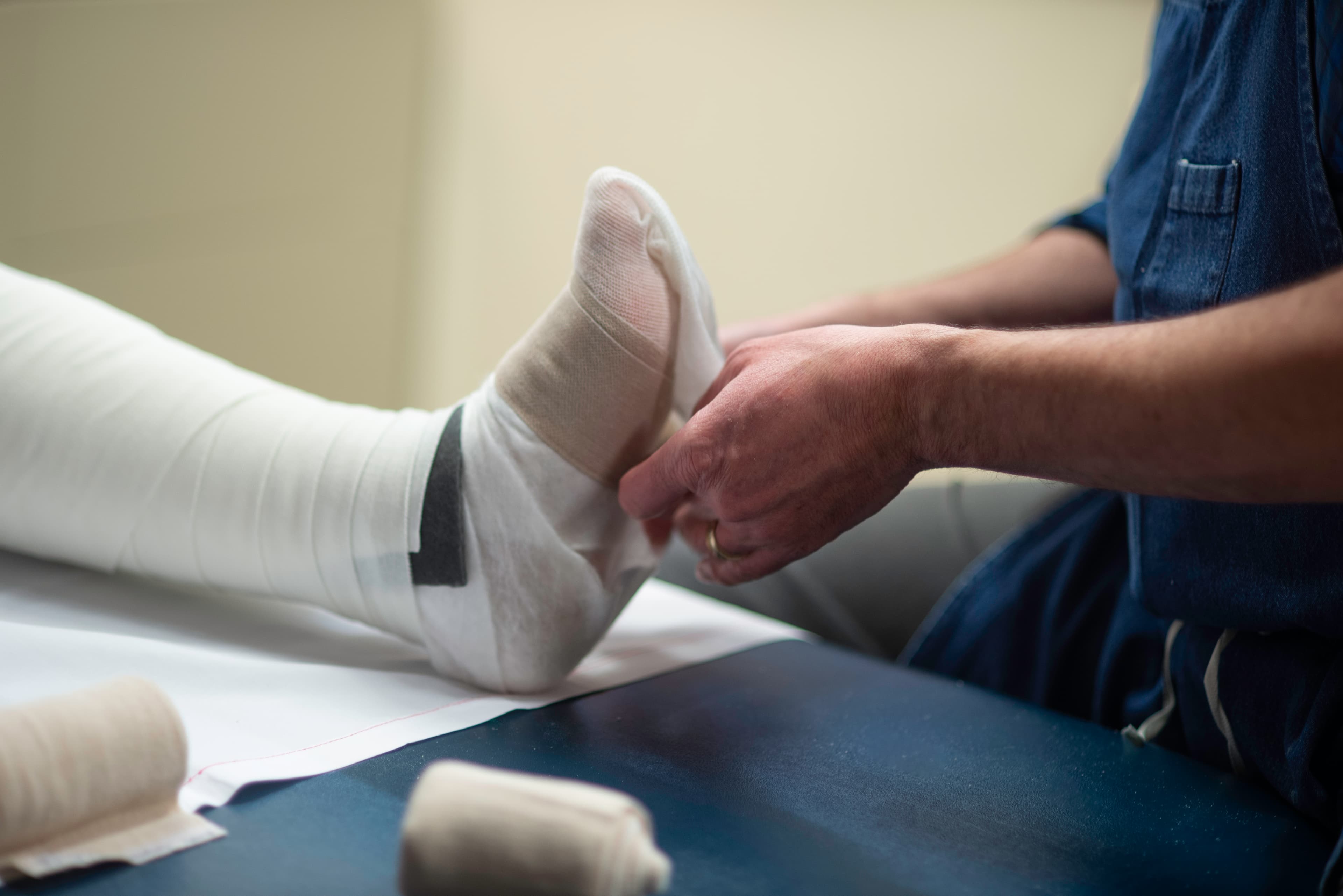 Lymphedema specialist applying customized compression bandage during intensive phase of CDT.