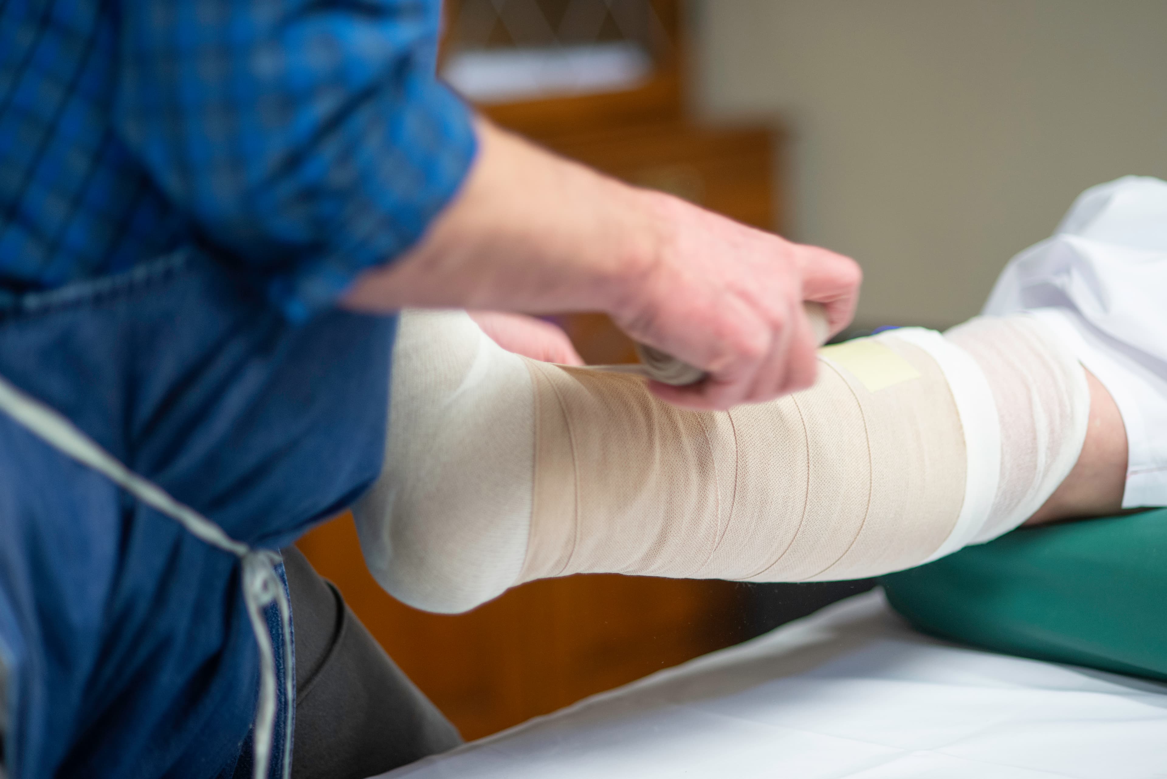 Lymphedema specialist applying customized compression bandage during intensive phase of CDT.