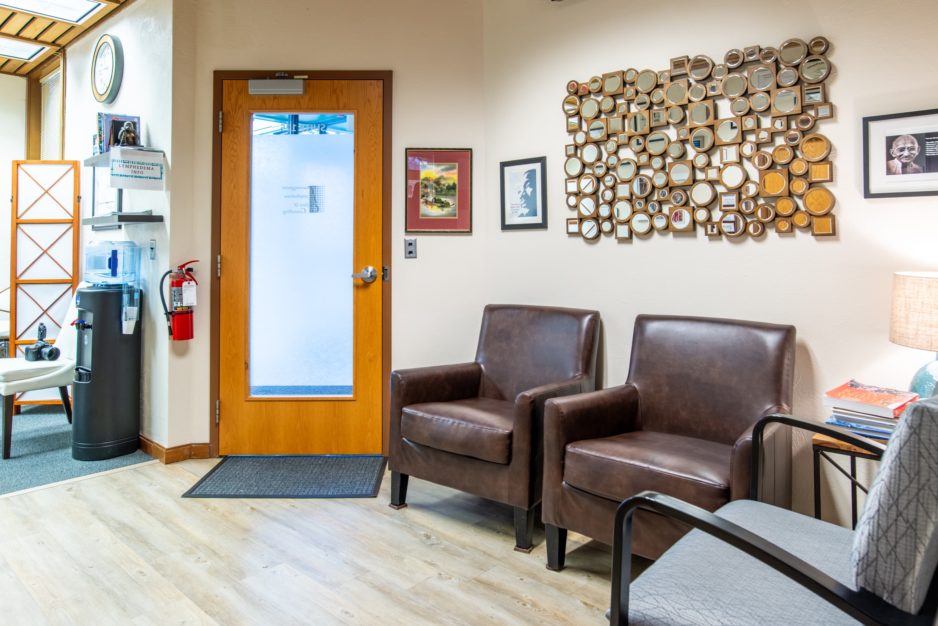 Front door of Turningpoint Lymphedema Clinic shows comfortable chairs, interesting wall decor and artwork, including a portrait and quotes from Martin Luther King Jr. and Ghandi.