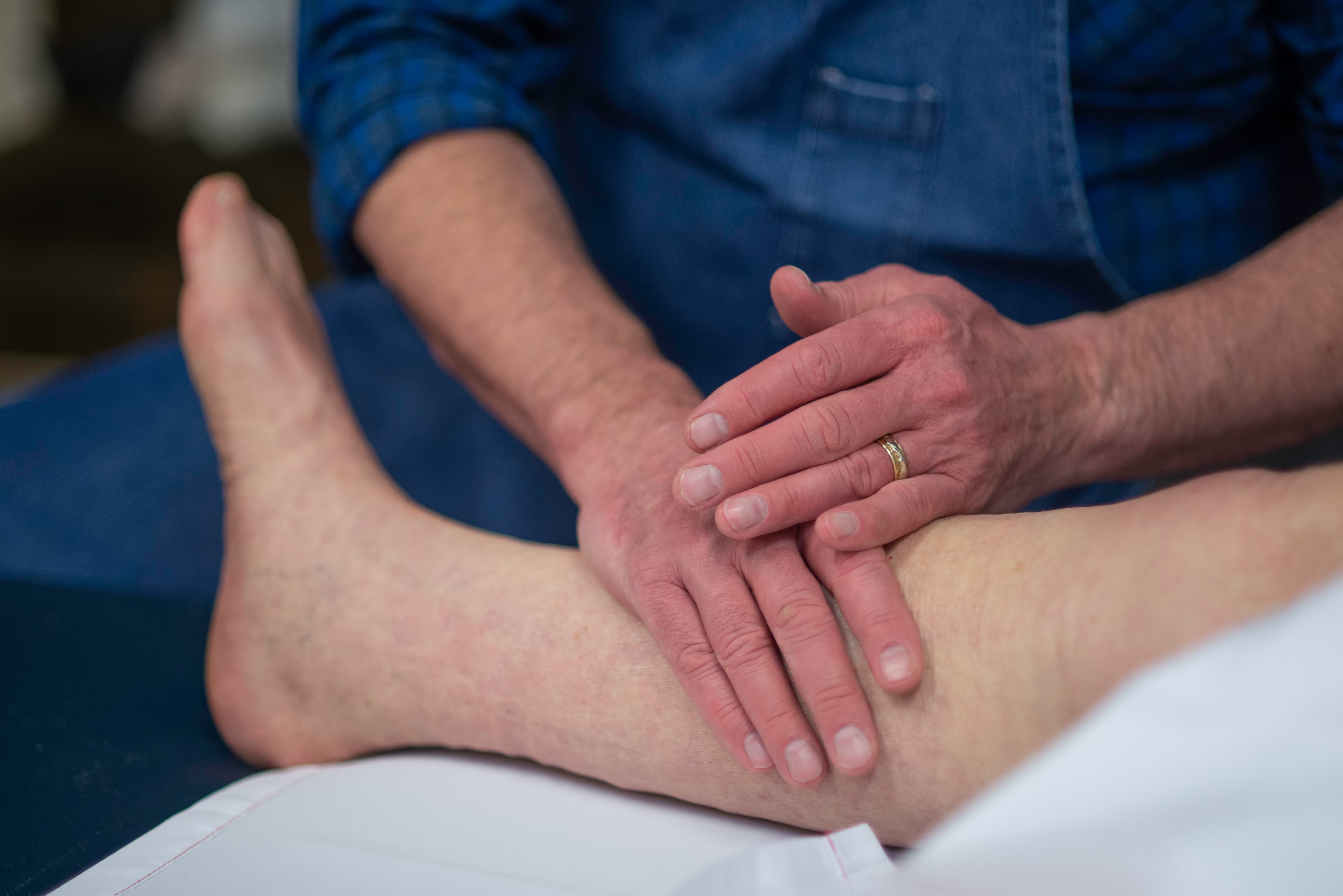 John massaging a patient's leg in one of the treatment rooms.