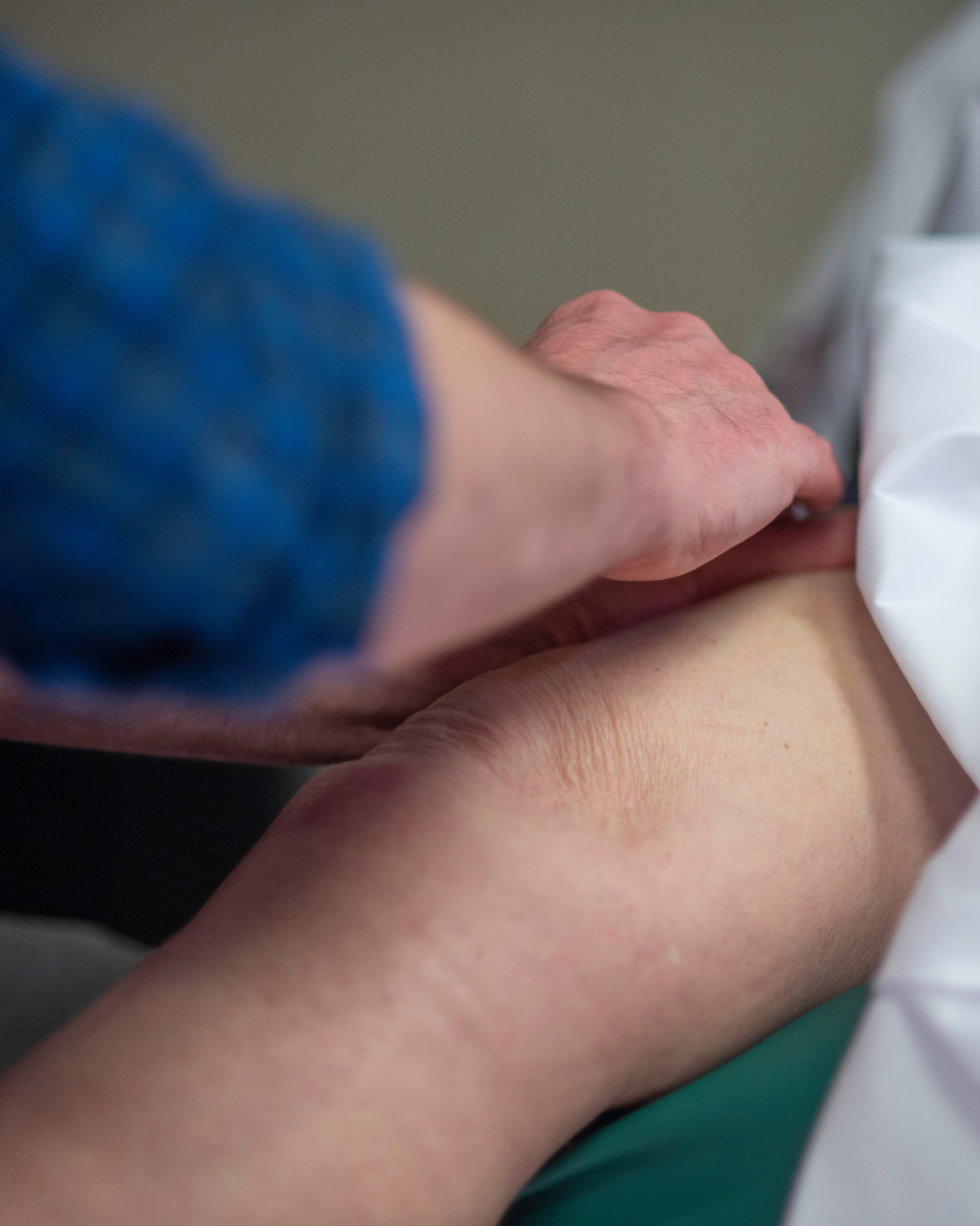 John massaging a patient's leg in one of the treatment rooms.