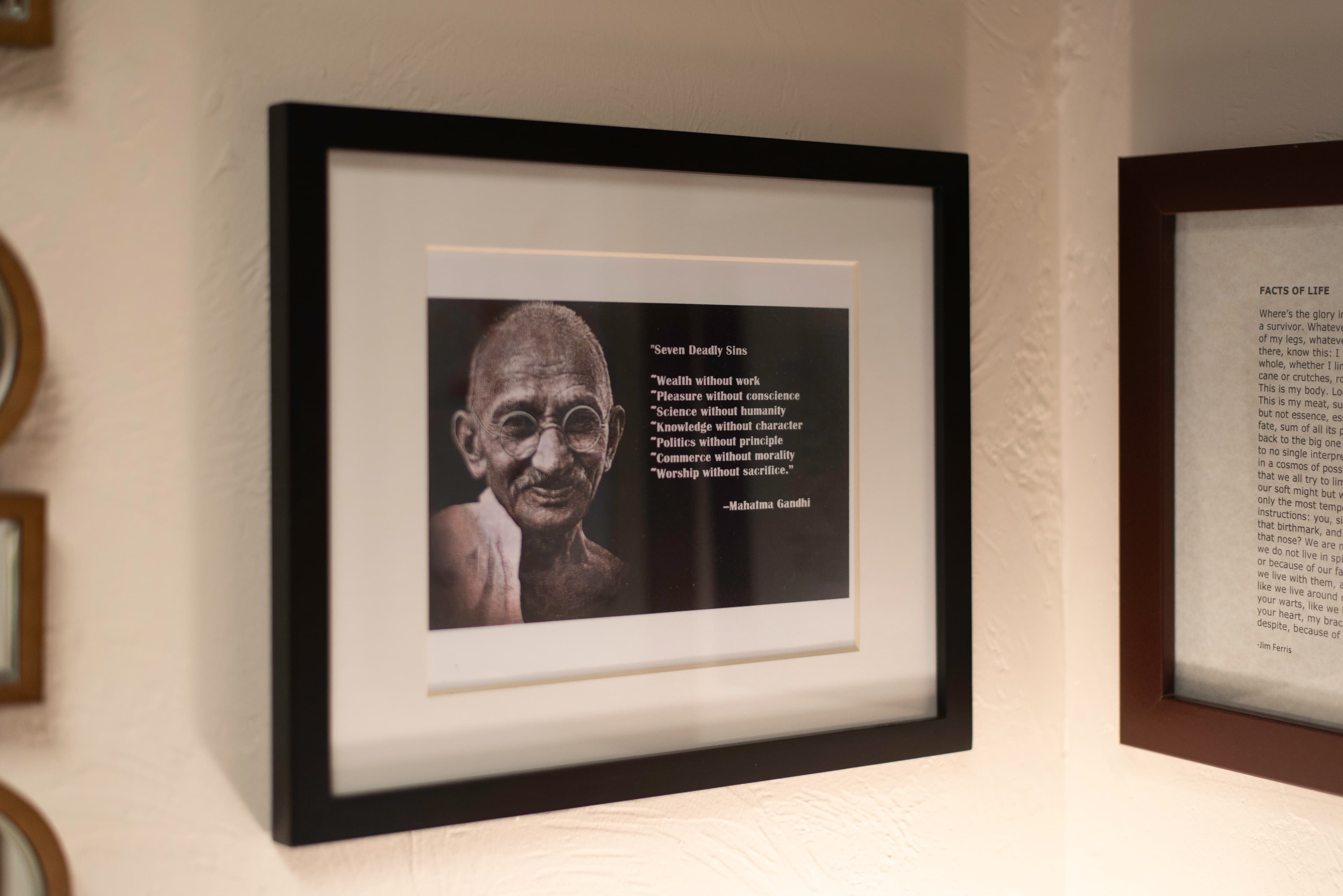 A framed image of Mahatma Gandhi with the following quote: "Seven Deadly Sins: wealth without work, pleasure without conscience, science without humanity, knowledge without character, politics without principle, commerce without morality, worship without sacrifice."